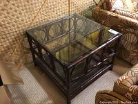 Full view of square bamboo frame table with glass top and lower shelf