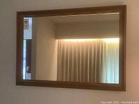 Front view of wood framed wall mirror showing reflective surface and frame color.