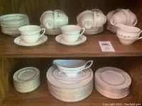 Full shelves display of dinner, salad and dessert plates, cups, saucers, creamer and gravy boat