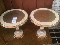 Pair of round wooden side tables with painted bases, glass tops visible on one table, missing glass on the other.