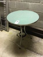 Full view of the vintage round table showing light blue tabletop and chrome base.
