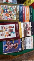 Books spread on a surface showing colorful volumes of The Encyclopedia of Collectibles and other collector reference books focused on antique items and collectibles.