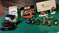 Photo showing various Harley Davidson collectible items including model vehicles, Christmas decor, and car banks arranged on a green felt surface.