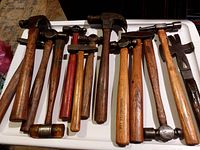 Full group of 13 hammers of varying sizes and styles including claw, ball peen, mallet, and specialty hammers on white tray
