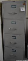 Front view of the gray Anderson Hickey four-drawer filing cabinet showing handles and label holders on each drawer.