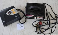 Photo showing both the Moto Master battery charger and Air Man air compressor together with cables and clamps