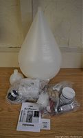 Full kit contents showing fermentation vessel, bags of corks, cleaning brush, tubing, stopper, and user manual.