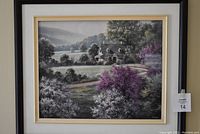 Frontal photo of the framed landscape painting showing the house among flowering trees and hills, within a black and gold frame with white mat