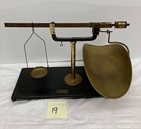 Full view of the Henry Troemner balance scale showing black base, horizontal beam, and brass weighing pans on either side.