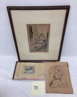 Framed cityscape etching along with two loose etchings; one depicting a religious scene and the other a small figure study inside a book or folder.