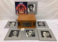 Full lot showing Crosley record player with seven framed vintage LP record albums arranged around it, two displayed atop the player.