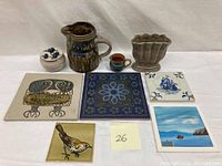 Full view of the vintage art tiles and pottery collection showing five tiles and four ceramic pieces.