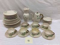 Overview of entire set: teapot, vase, stacks of plates, cups and saucers