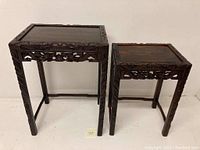 Front and side view of the two vintage Chinese carved wooden end tables with dragon designs, showing size difference.