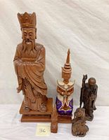 Photo showing all five wooden statues on a white surface with plain backdrop.