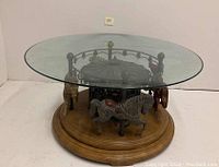 Full view of round glass tabletop over carousel horse base