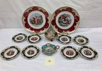 Group photo showing a set of 13 porcelain plates including different sizes and border colors, one small bowl with lid, and one uniquely shaped small plate with handle, showcasing intricate classical hand-painted artwork and gold detailing.