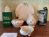 Full view of Belleek china items including plate, creamer, bowl, shell-shaped dish, and boxed Irish Snowman figurine