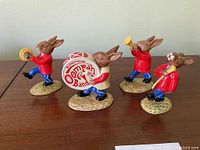 Four Bunnykins Oompah Band rabbit figurines viewed from front and side angles, showing instruments and colorful details.