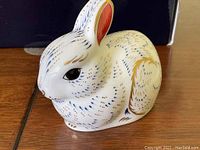 Close-up of the rabbit figurine showing detailed blue and gold hand-paint work.