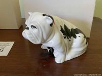 Three-quarter side view of white and black bulldog figurine on table