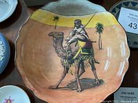 Full view of camel-themed bowl with desert scene showing crazing, discoloration and small crack