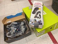 Photo of Forum snowboard boots in box and box of Icers anti-skid safety soles on green surface
