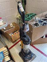 Full view of upright vacuum cleaner including handle, dust canister, and base with control dial.