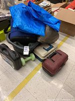 Image showing the collection of items including folded tarp, sleeping bag, inflatable exercise ball, tackle boxes, soft cooler, and laundry basket.
