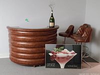 Semicircular bar, four stools, bottle, framed poster