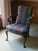 Side angle view of the Hancock and Moore striped fabric armchair showing wooden cabriole legs, open arms, and nailhead trim.