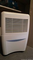 White Whirlpool dehumidifier front and side views showing vent panels and overall condition.