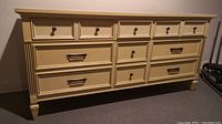Front diagonal view of Malcolm 9 drawer dresser showing drawer hardware and wear.