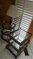 Photo of the two three-tier glass top wood frame end tables with brass accents and the brass base table lamp with pleated shade.