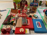 Overview of all items on a white table including various toys, games, and cases