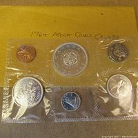 Full view of the six Canadian 1964 coins in sealed plastic with original yellow envelope background