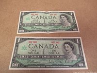 Two Canadian Centennial one dollar bills side by side showing front design with Queen Elizabeth II and commemorative dates.