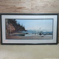 Full‐width view of the framed panoramic print leaning against wood wall