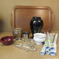 Photo showing the assortment of items including wooden tray, glass and ceramic bowls, vase, container, metal cup, glass tongs, and rolls of shelf liners