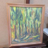 Photo showing framed oil painting of forest scene by RJ Pethick with visible brushstrokes and color blending.