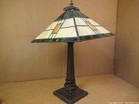 Full view of the Tiffany-style stained glass table lamp with geometric patterns and a metal base.