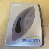Top view showing silver walkman body with Mega Bass logo and anti-rolling mechanism text.