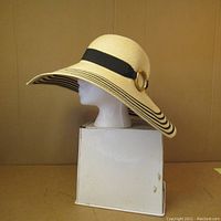 Side profile of the full vintage sun hat showing wide brim with black stripes and black ribbon around crown.