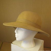 Side profile of the vintage tan felt sun hat on a mannequin head showing wide brim and stitched band detail.