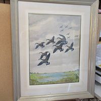 Full frontal view of the framed watercolour showing a flock of geese against a cloudy sky and marsh