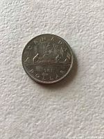 Reverse side of the coin showing canoe design with paddlers and sail, and inscriptions.