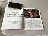 Open book showing Ghostbusters II title and introduction page with photos and text