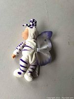 Side view of the Anne Geddes baby butterflies doll showing purple and white outfit and wings.