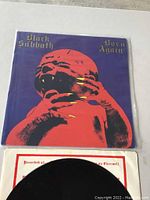 Front cover of Black Sabbath Born Again LP featuring distinctive red baby on purple background.