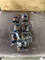 Seven unopened collectible Star Wars The Clone Wars skateboard toys from McDonald's 2010 set, arranged on carpet.